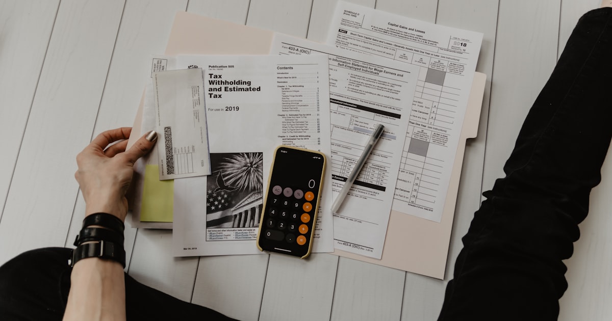 Calculating the total cost of an office lease in Singapore with calculator and financial documents
